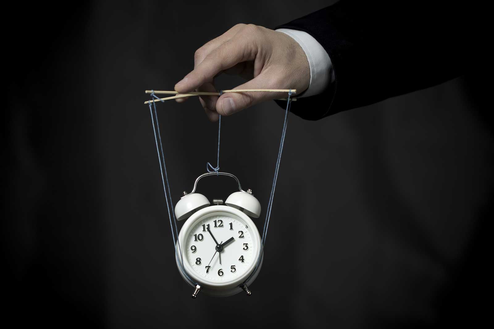 THINK-JAN-PIC—bigstock-Hand-Holds-A-Clock-Hanging-On-87475943